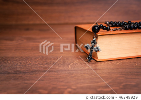 Rosary on the Bible at wooden table Rosary on the Bible at wooden table 46249929