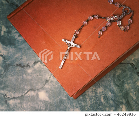 Rosary and cross resting on the closed book Rosary and cross resting on the closed book 46249930