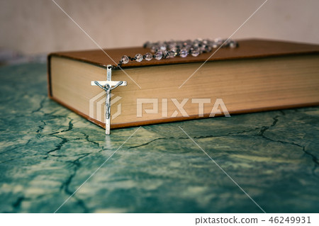 Silver rosary resting on closed book front view Silver rosary resting on closed book front view 46249931