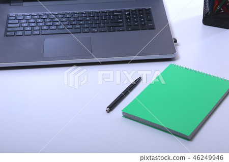 Modern white office desk table with laptop, smartphone and other supplies. Blank notebook page for Modern white office desk table with laptop, smartphone and other supplies. Blank notebook page for 46249946