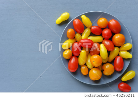 Organic fresh tomatoes on grey plate Organic fresh tomatoes on grey plate 46250211