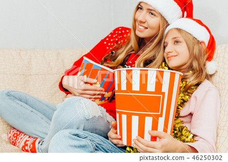 Mom and her little daughter, dressed in Santa  46250302