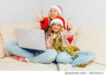 Young mother and her daughter dressed in Santa Young mother and her daughter dressed in Santa 46250311