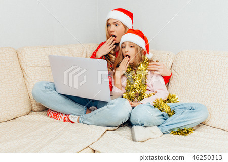 Shocked mom and her daughter, dressed in Santa's Shocked mom and her daughter, dressed in Santa's 46250313