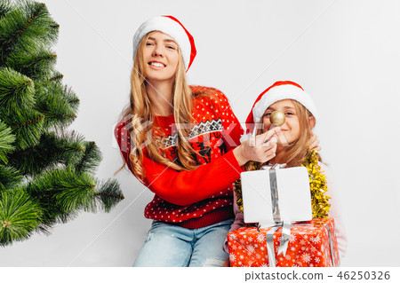 Mom and daughter are wearing Santa Claus hats Mom and daughter are wearing Santa Claus hats 46250326