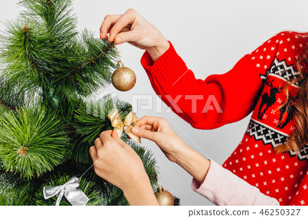 Closeup, hands decorate the Christmas tree Closeup, hands decorate the Christmas tree 46250327