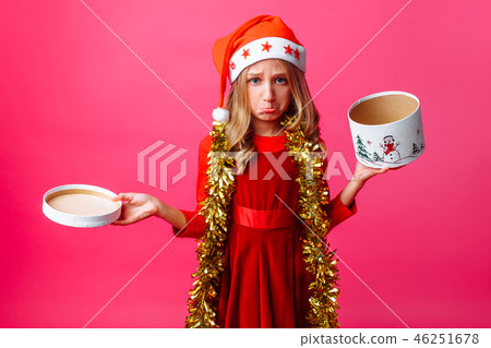 Frustrated teenage girl in Santa hat and tinsel Frustrated teenage girl in Santa hat and tinsel 46251678