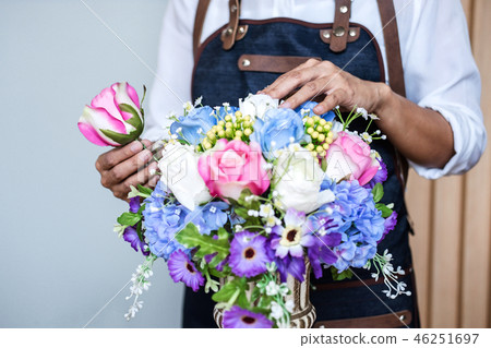 Arranging artificial flowers vest decoration at home, Young woma 46251697