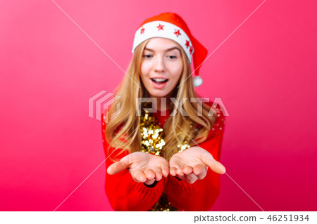 Girl in red sweater, Santa hat and tinsel on neck 46251934