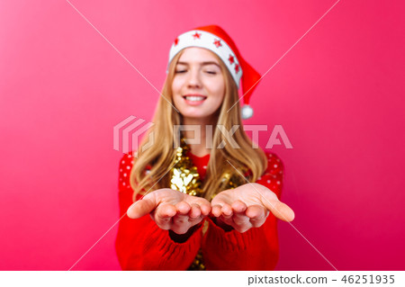 Girl in red sweater, Santa hat and tinsel on neck 46251935