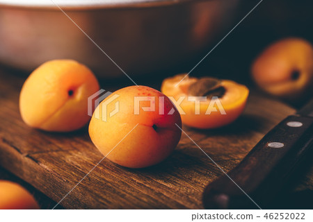 Mellow apricots with knife over cutting board Mellow apricots with knife over cutting board 46252022