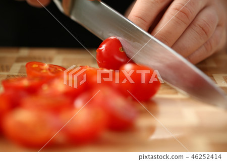 Cook holds knife in hand and cuts on Cook holds knife in hand and cuts on 46252414