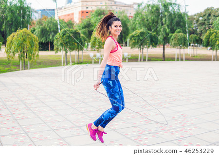 Fit beautiful woman with jumping rope in a park Fit beautiful woman with jumping rope in a park 46253229