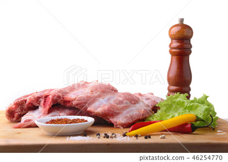Raw Ribs on a rustic cutting board with salt, pepper and grinder for spices . White Background for 46254770