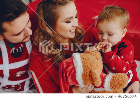 Cute young family sitting at home on a bed Cute young family sitting at home on a bed 46256574