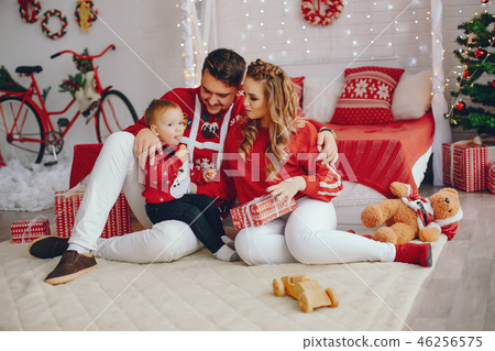 Cute young family sitting at home on a bed Cute young family sitting at home on a bed 46256575
