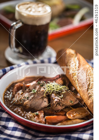 Roast wild boar with carrot mushrooms and baguette 46261519