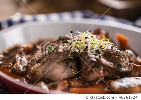 Roast wild boar with carrot mushrooms and baguette 46261524