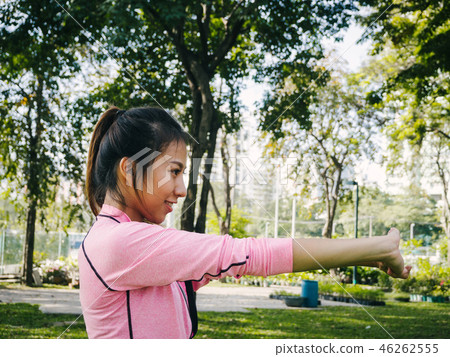 woman warm up body by stretch her arms in park. 46262555