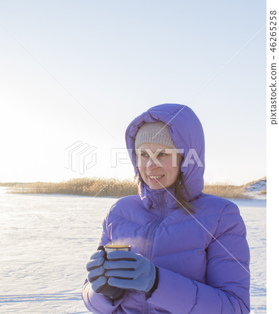 Young woman with a cup of hot drink in winter wood Winter woman on background of winter landscape Young woman with a cup of hot drink in winter wood Winter woman on background of winter landscape 46265258