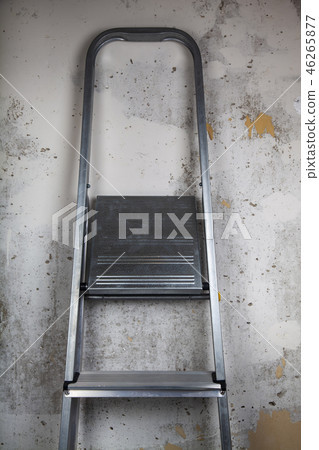 Stepladder on a gray wall background. 46265877