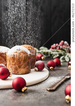 Sprinkling powdered sugar over Christmas Panettone Sprinkling powdered sugar over Christmas Panettone 46272313