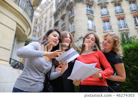 Foreign students learning English with papers near university bu 46274303