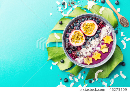Smoothie acai bowl served in bowl on blue table 46275509