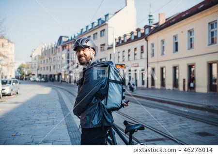 Male courier with backpack delivering packages in city. Male courier with backpack delivering packages in city. 46276014