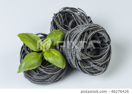 Raw uncooked pasta with basil leaves isolated Raw uncooked pasta with basil leaves isolated 46276426