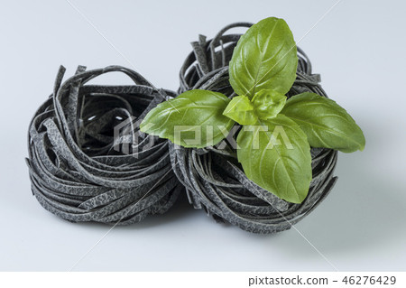 Raw uncooked pasta with basil leaves isolated 46276429