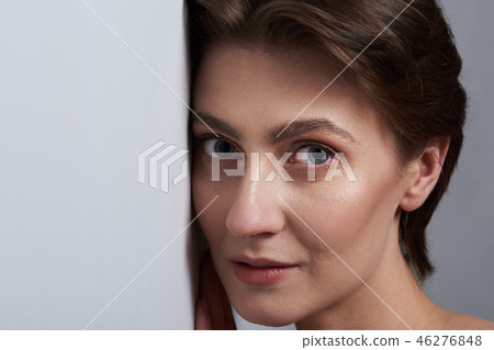 Woman face lean to white wall Woman face lean to white wall 46276848