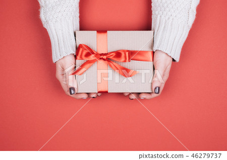 Gift box with bow in woman's hands. 46279737