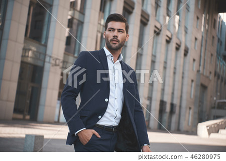 Confident businessman. Confident young man in full suit adjusting his sleeve and looking away while Confident businessman. Confident young man in full suit adjusting his sleeve and looking away while 46280975