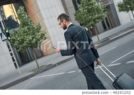 A young businessman with glases is chatting on his smartphone A young businessman with glases is chatting on his smartphone 46281202