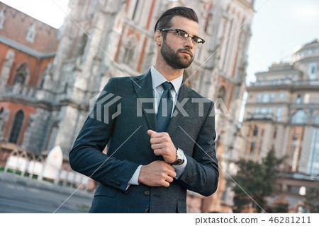 Close up profile portrait of a successful young bearded guy in suit and glasses. So stylish and 46281211