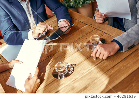 Business lunch. Three people in the restaurant sitting at table brainstorming working on project Business lunch. Three people in the restaurant sitting at table brainstorming working on project 46281639