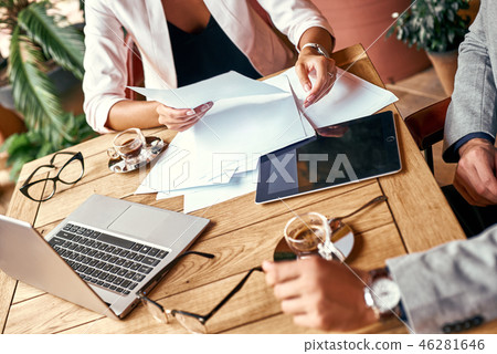 Business lunch. Man and woman sitting at table at restaurant looking at documents working on project Business lunch. Man and woman sitting at table at restaurant looking at documents working on project 46281646