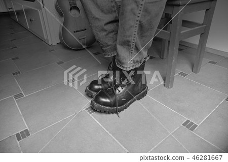 Rock and roll concept. Black boots and classic guitar. Black and white image 46281667