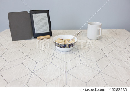 Electronic book and a cup of coffee on the table Electronic book and a cup of coffee on the table 46282383