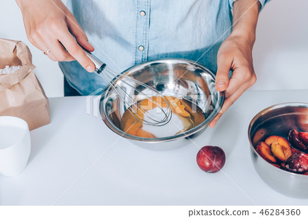Close-up female's hands whisk raw eggs with sugar 46284360