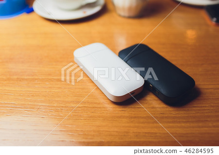 Photo product IQOS 2.4 plus heat control technology electronic cigarette and FIIT change up on wood Photo product IQOS 2.4 plus heat control technology electronic cigarette and FIIT change up on wood 46284595