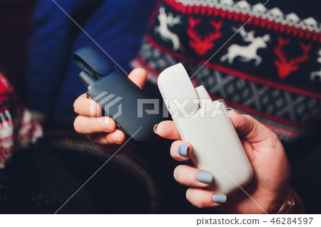 A heat-not-burn tobacco product technology.man and woman holding a bar. A heat-not-burn tobacco product technology.man and woman holding a bar. 46284597