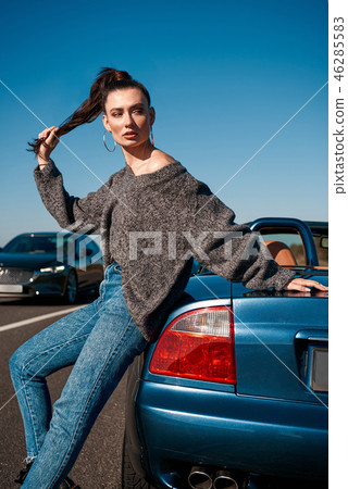 Young woman with a tail standing near roofless car outdoors 46285583