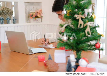 man writing christmas letter greeting card holiday wishes with xmas decoration 46286704