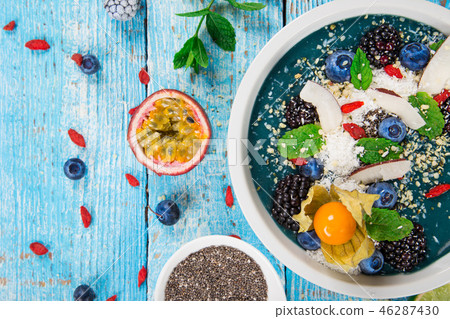 Smoothie bowl with fresh berries, nuts, seeds, fruit and vegetables. Smoothie bowl with fresh berries, nuts, seeds, fruit and vegetables. 46287430