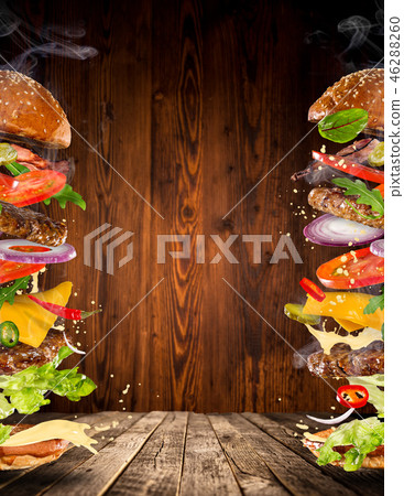 Big tasty burger with flying ingredients. 46288260