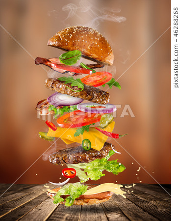 Big tasty burger with flying ingredients. Big tasty burger with flying ingredients. 46288268