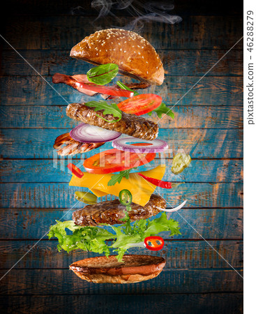 Big tasty burger with flying ingredients. Big tasty burger with flying ingredients. 46288279