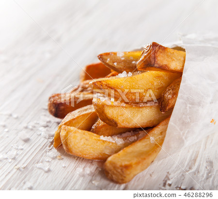 French fries in a little white paper bag. French fries in a little white paper bag. 46288296